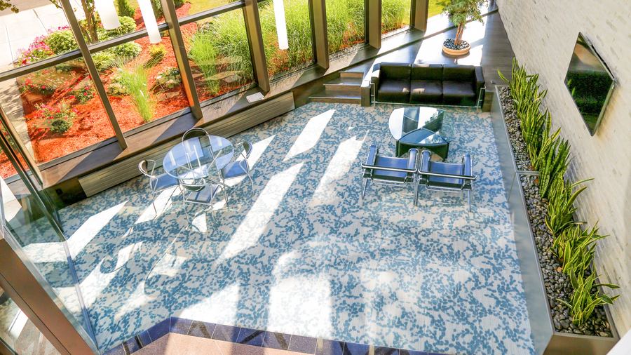 Sunlit glass atrium with seating, seen from above